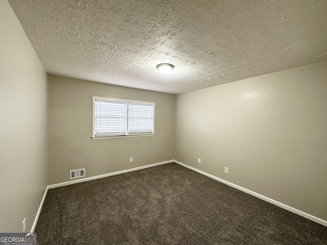 carpeted spare room featuring a textured ceiling