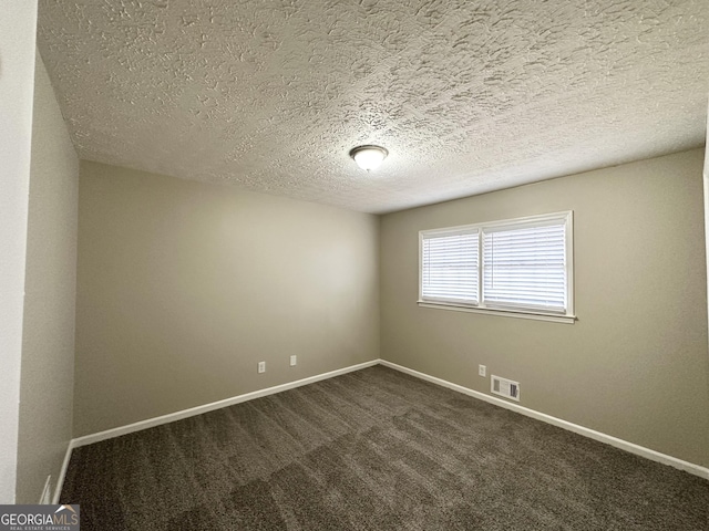 unfurnished room featuring dark carpet and a textured ceiling