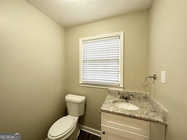 bathroom featuring vanity, toilet, and a textured ceiling