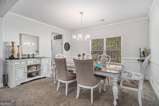 carpeted dining space featuring an inviting chandelier and ornamental molding