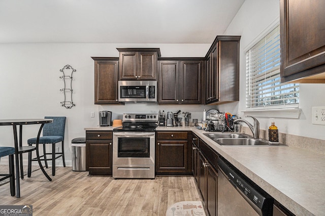 kitchen featuring dark brown cabinets, light hardwood / wood-style floors, sink, and appliances with stainless steel finishes