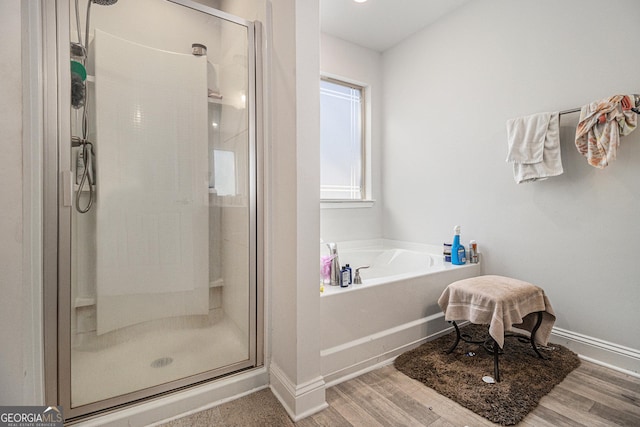 bathroom with hardwood / wood-style flooring and independent shower and bath