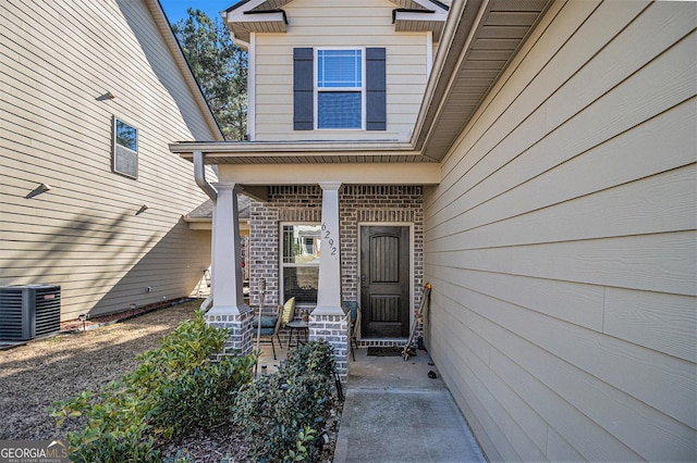 entrance to property with central AC unit and a porch