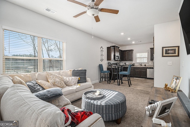 living room featuring a wealth of natural light, sink, ceiling fan, and light hardwood / wood-style floors