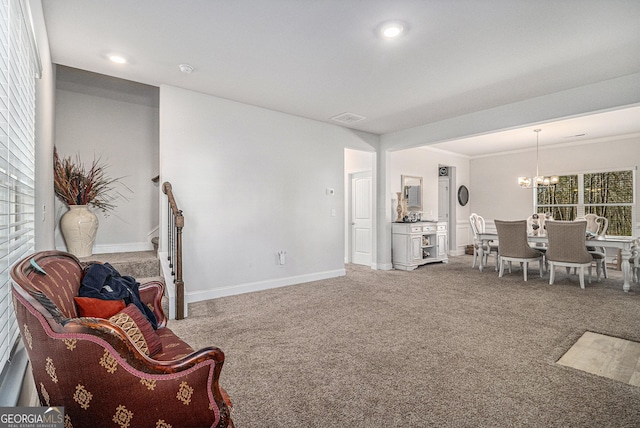 carpeted living room with a chandelier and crown molding