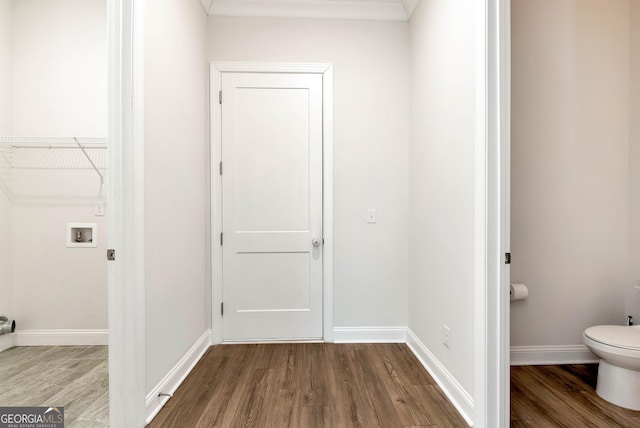 interior space featuring washer hookup, wood-type flooring, and ornamental molding