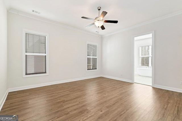 spare room featuring hardwood / wood-style floors, ceiling fan, and crown molding