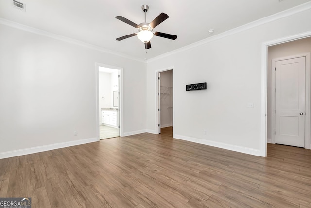 spare room featuring ceiling fan, ornamental molding, and light wood-type flooring