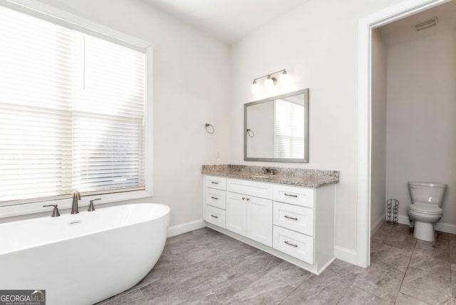 bathroom with vanity, toilet, and a tub