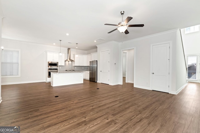 unfurnished living room with ceiling fan, dark hardwood / wood-style flooring, crown molding, and plenty of natural light