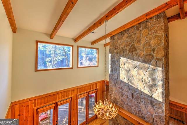 interior space with wooden walls, french doors, and beamed ceiling