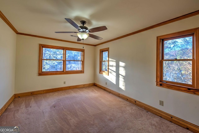 spare room featuring light carpet, crown molding, ceiling fan, and a healthy amount of sunlight