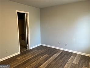 empty room featuring dark hardwood / wood-style flooring