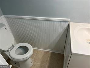 bathroom featuring tile patterned flooring, vanity, and toilet