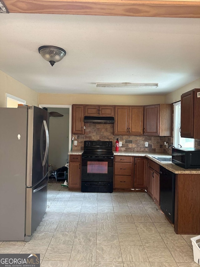 kitchen featuring sink, backsplash, and black appliances