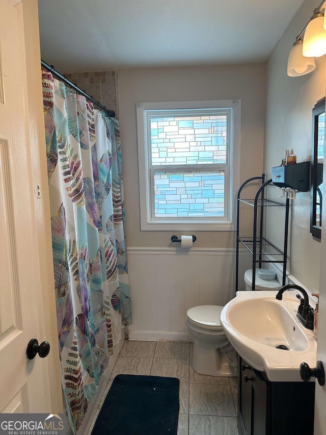 bathroom featuring tile patterned flooring, vanity, a shower with shower curtain, and toilet