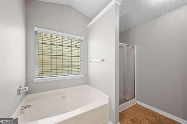 bathroom with a textured ceiling, separate shower and tub, plenty of natural light, and lofted ceiling