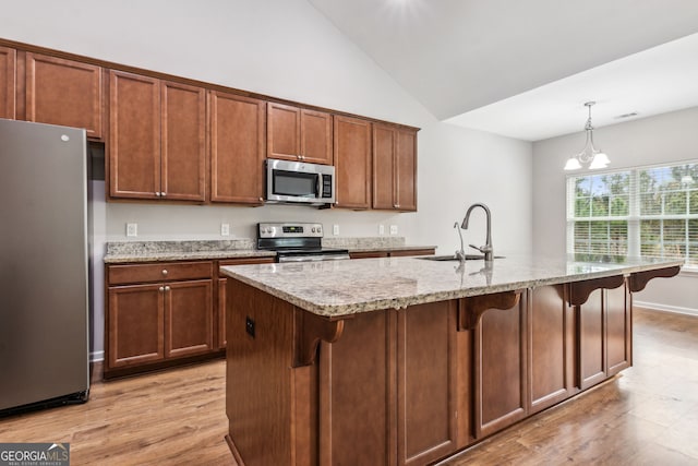 kitchen featuring a center island with sink, sink, stainless steel appliances, and a chandelier