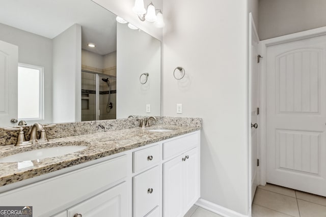 bathroom with tile patterned floors, vanity, and a shower with door