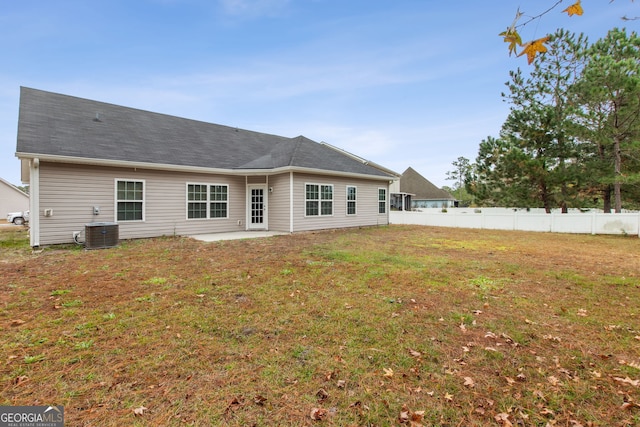 rear view of property with central air condition unit, a yard, and a patio