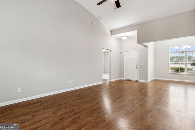 unfurnished living room featuring dark hardwood / wood-style floors, ceiling fan with notable chandelier, and high vaulted ceiling