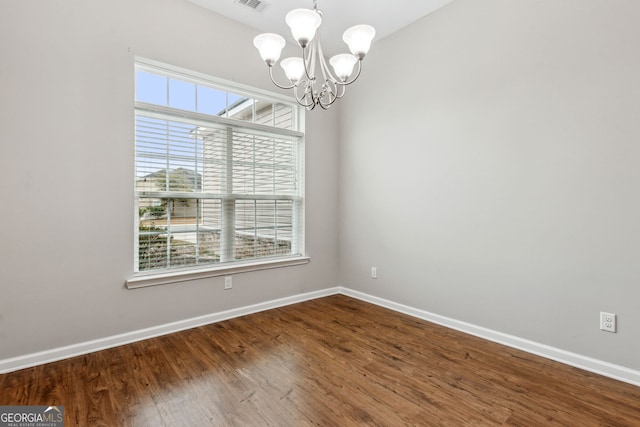 unfurnished room featuring hardwood / wood-style floors and a notable chandelier