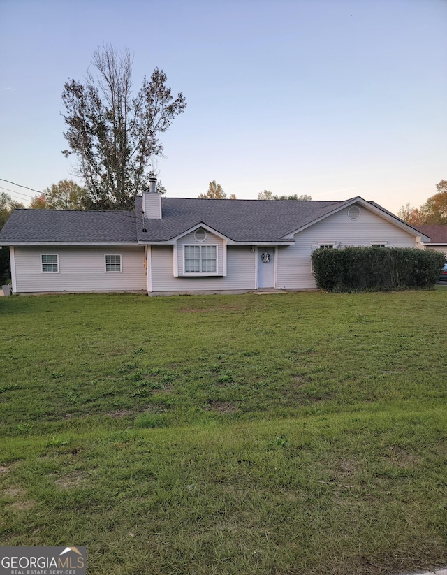 ranch-style home featuring a yard