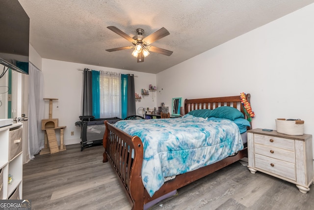 bedroom featuring a textured ceiling, a ceiling fan, and wood finished floors