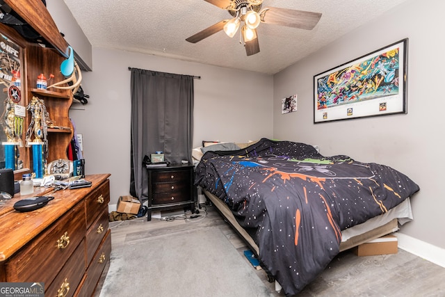 bedroom featuring a textured ceiling, ceiling fan, and baseboards