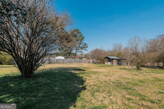 view of yard with an outdoor structure and fence