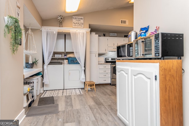 kitchen featuring light wood-style flooring, appliances with stainless steel finishes, white cabinets, vaulted ceiling, and independent washer and dryer