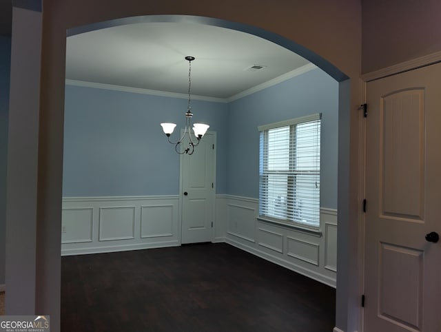 unfurnished dining area featuring a chandelier, dark wood-type flooring, and crown molding