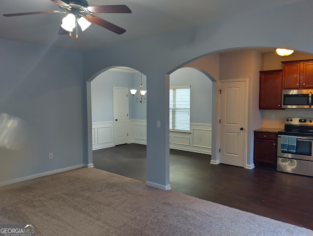 kitchen featuring ceiling fan with notable chandelier, dark carpet, and appliances with stainless steel finishes