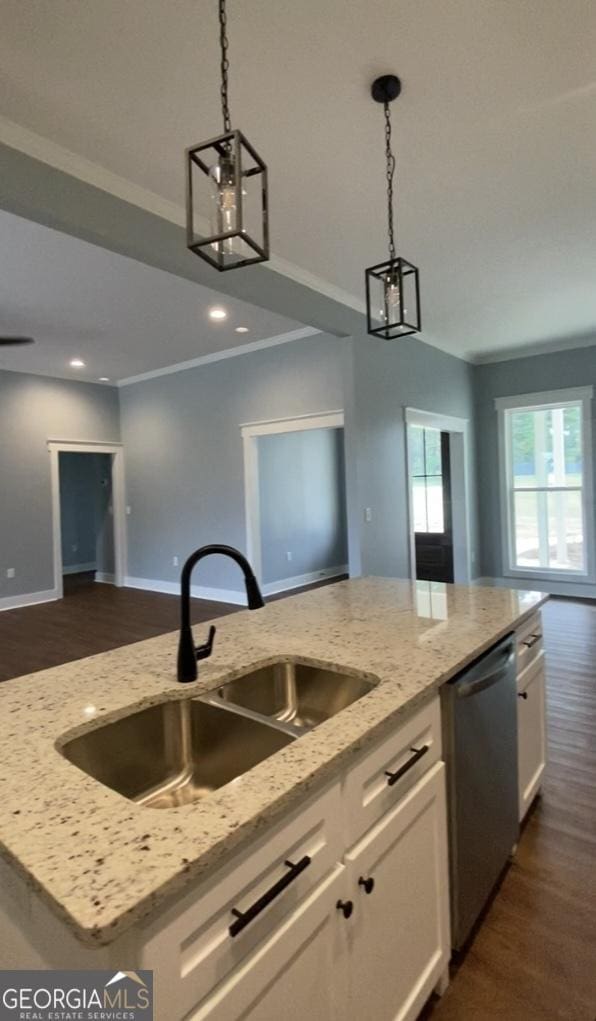 kitchen with stainless steel dishwasher, sink, a center island with sink, white cabinets, and hanging light fixtures