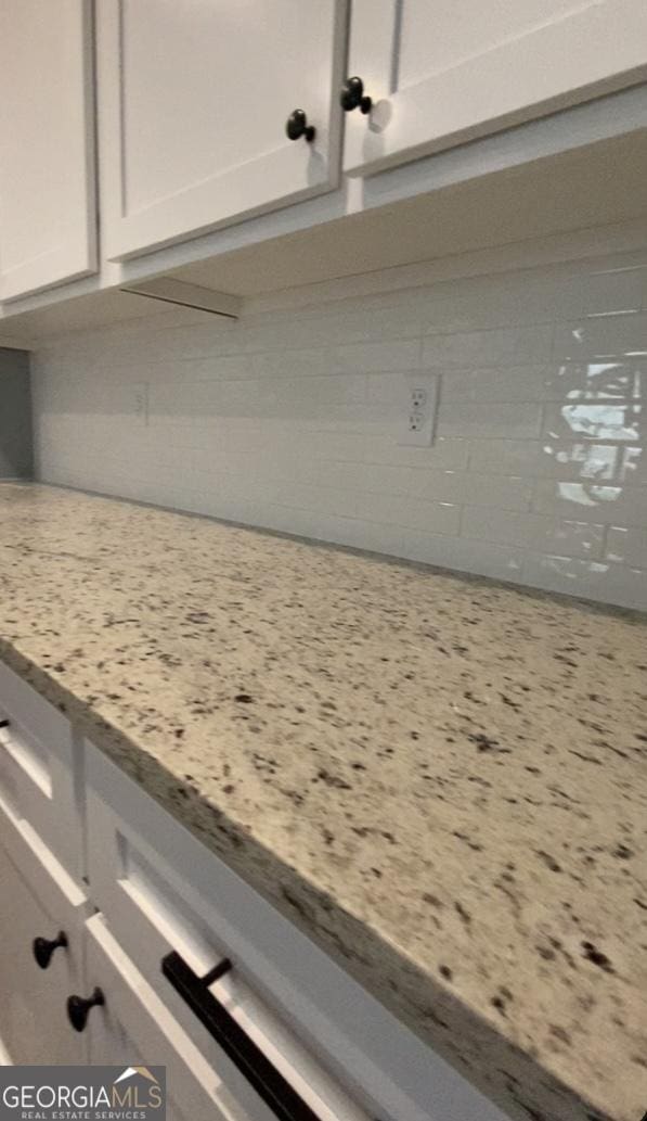 details featuring light stone counters and white cabinets