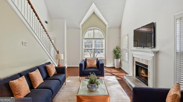 living room with a tiled fireplace and hardwood / wood-style flooring