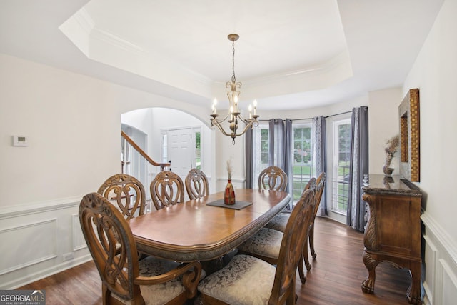 dining area with dark hardwood / wood-style flooring, a raised ceiling, and a chandelier