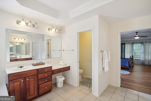 bathroom featuring tile patterned floors, a raised ceiling, ceiling fan, crown molding, and toilet