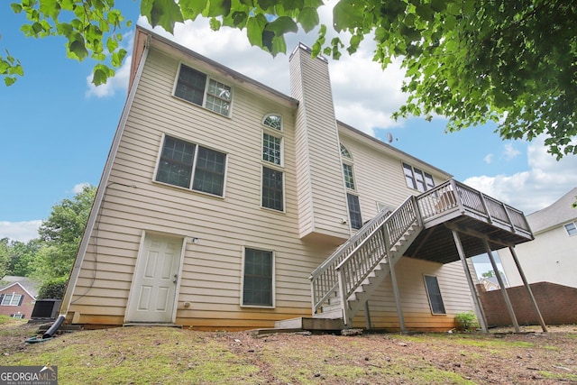 rear view of house featuring a wooden deck