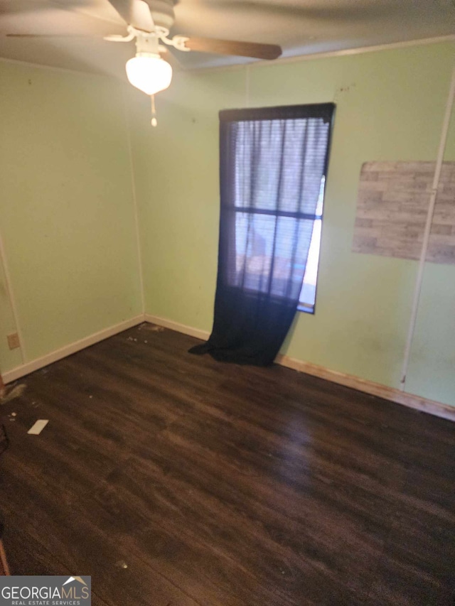 unfurnished room featuring ceiling fan and dark wood-type flooring