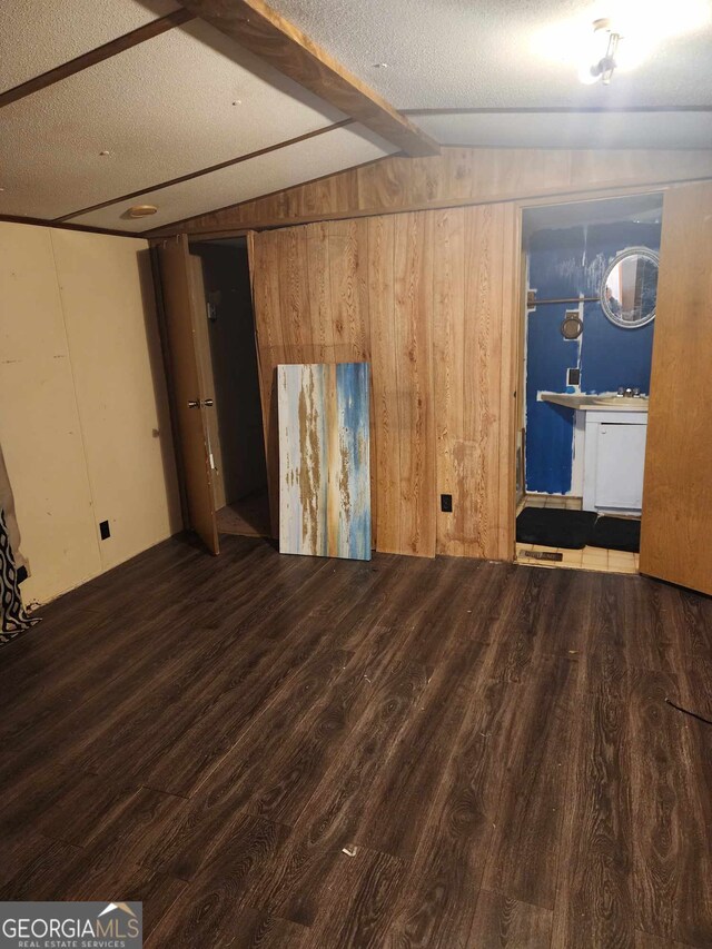 interior space with wood-type flooring, a textured ceiling, and wooden walls