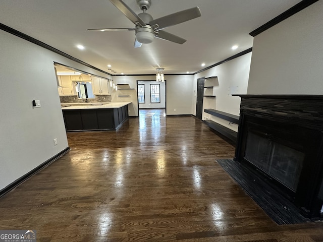 living room with ceiling fan, sink, and ornamental molding