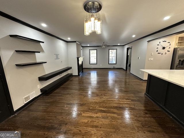 interior space featuring dark hardwood / wood-style flooring, ceiling fan with notable chandelier, and crown molding