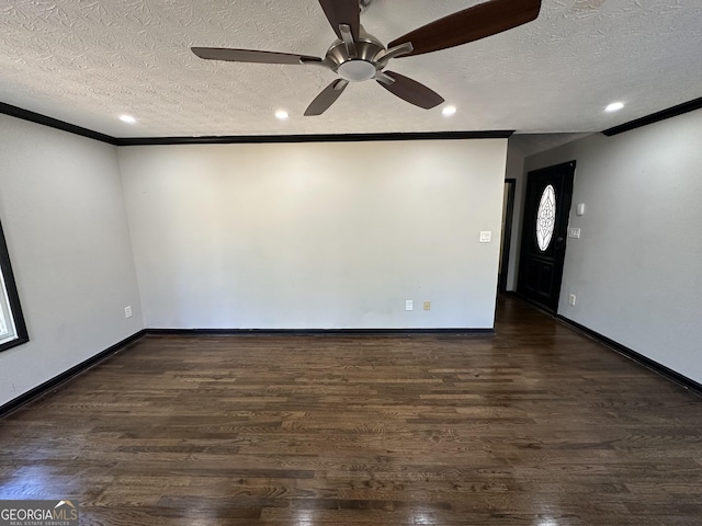 spare room with crown molding, ceiling fan, dark wood-type flooring, and a textured ceiling