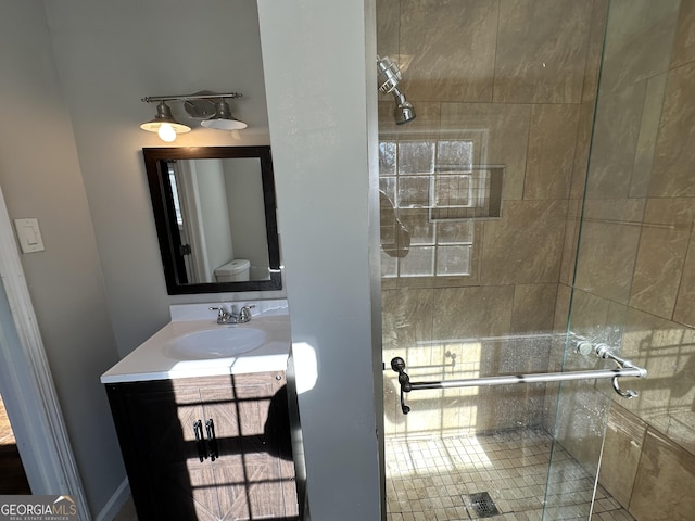 bathroom with vanity, toilet, and an enclosed shower