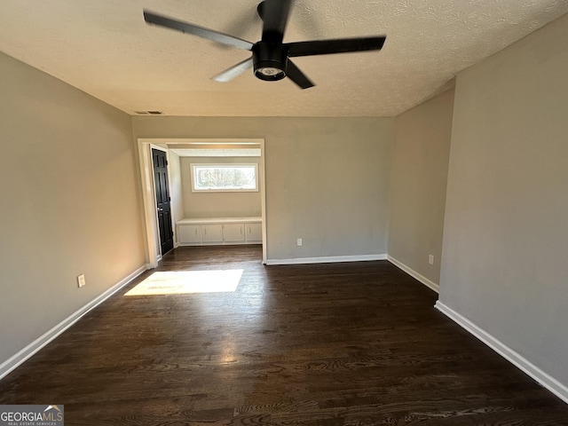 empty room featuring a textured ceiling, dark hardwood / wood-style flooring, and ceiling fan