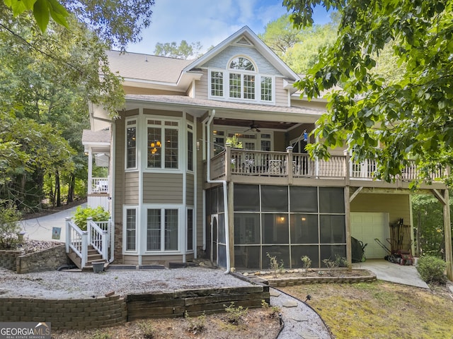 back of property featuring a sunroom and a garage