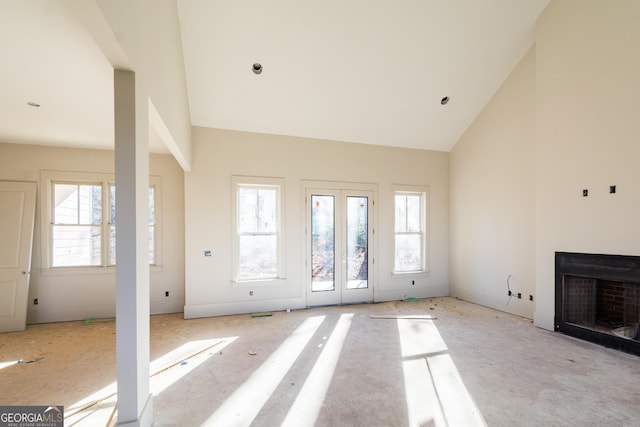 unfurnished living room with high vaulted ceiling