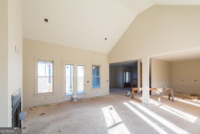 unfurnished living room with high vaulted ceiling