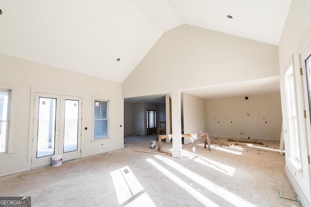 unfurnished living room with french doors and high vaulted ceiling